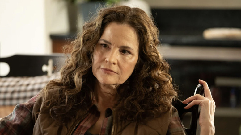 Ally Sheedy as Rose Pruett sitting in a chair in Wild Cards