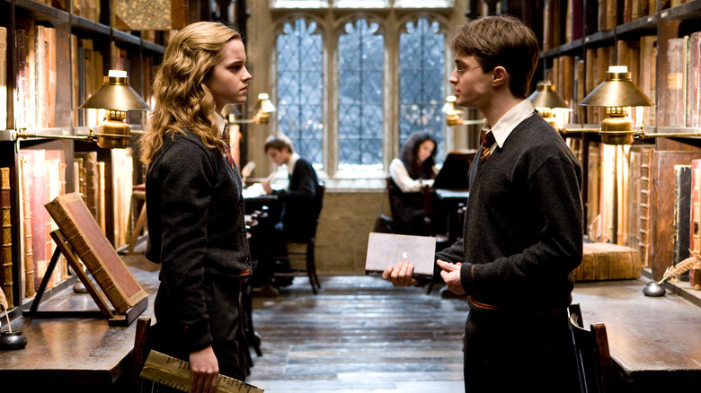 Hermione and Harry talking in the library in Harry Potter