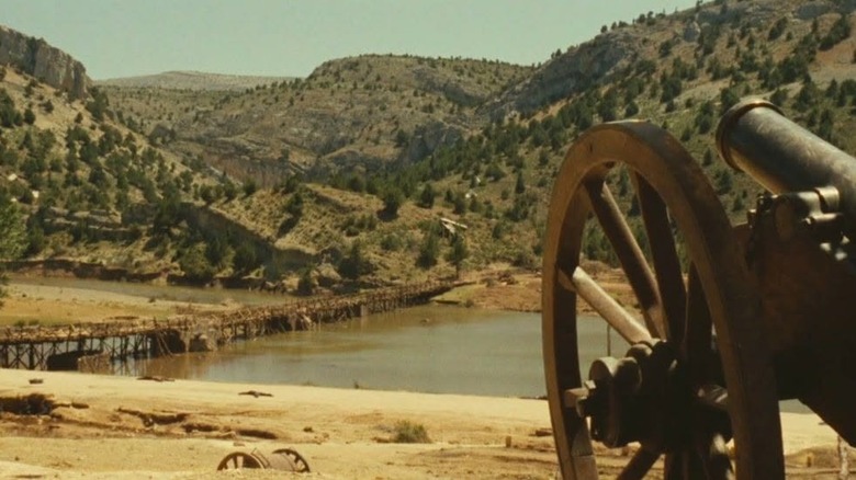 The Good, the Bad, and the Ugly landscape shot showing a bridge in distance and cannon in foreground