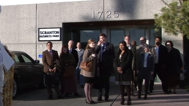 The cast of The Office stands outside the Dunder Mifflin building in The Office