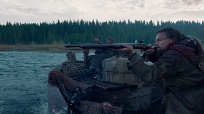Hugh Glass firing a rifle from a boat in The Revenant.