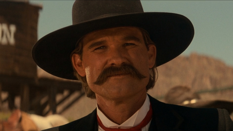 Kurt Russell as Wyatt Earp wearing a cowboy hat in Tombstone