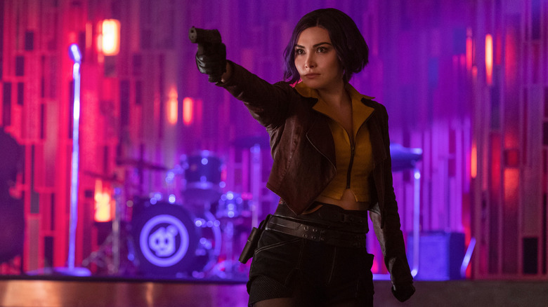 Daniella Pineda as Faye Valentine holding up her gun in Cowboy Bebop