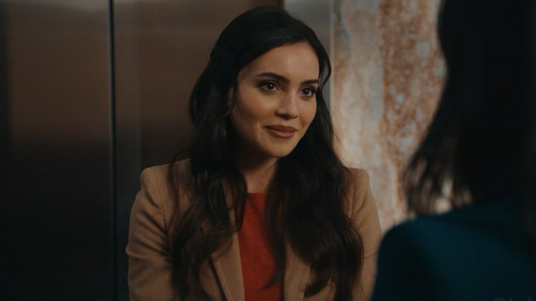 Andrea Londo as Simone smiling in front of an elevator on Matlock
