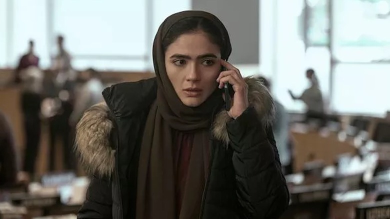 Arienne Mandi takes an urgent phone call as Noor Taheri in The Night Agent