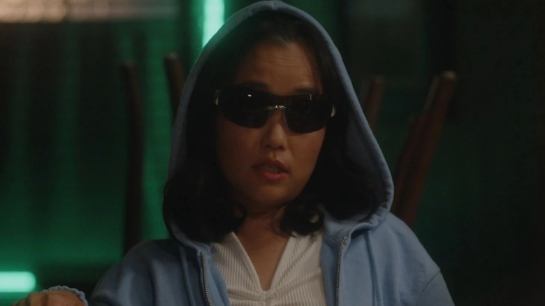 Ellen wears a hoodie and sunglasses while playing poker in Resident Alien