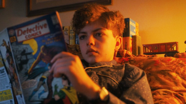 Mikkal Karim-Fidler's Theodore Uris sits in bed reading a comic in It: Welcome to Derry