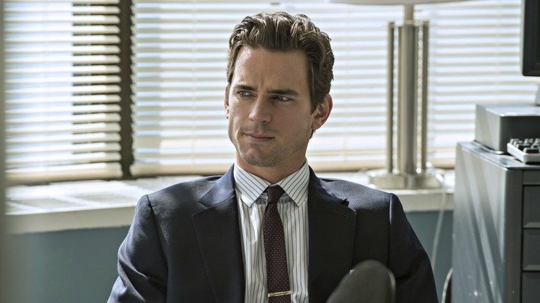 Neal Caffrey sitting at a desk looking confused in White Collar