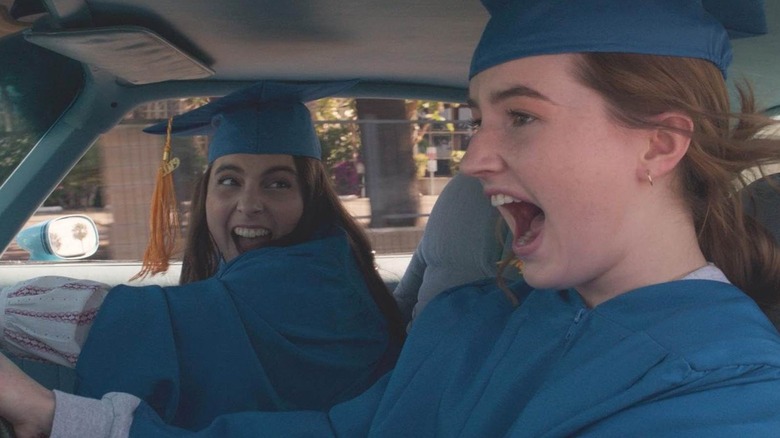 Beanie Feldstein and Kaitlyn Dever driving graduaton robes in Booksmart
