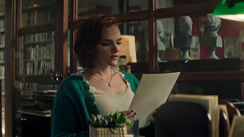 Bronte reading Joe's manuscript in his office in the bookstore on You