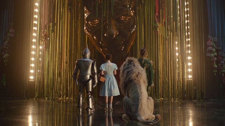 The Tin Man, Dorothy, the Cowardly Lion, and the Scarecrow facing the Wizard of Oz in Wicked: For Good