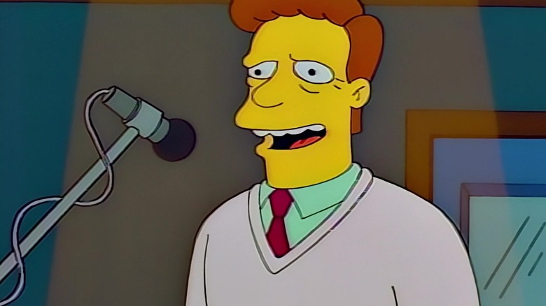 Troy McClure standing at a microphone
