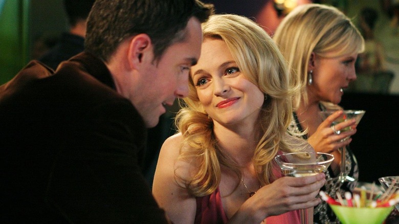 Emily looking wincingly at a fellow in Emily's Reasons Why Not. She is holding a martini.