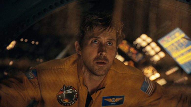 Ryan Gosling as Ryland Grace looking through the window of his ship in Project Hail Mary