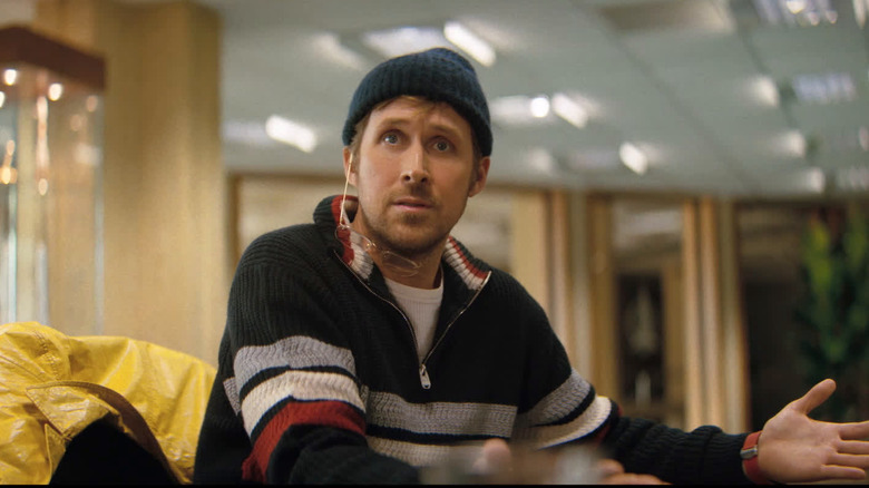 Ryan Gosling as Ryland Grace sitting at a table with his glasses hanging off his ear in Project Hail Mary