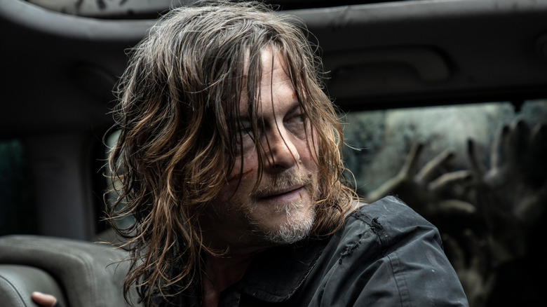 Norman Reedus as Daryl Dixon in a car surrounded by zombies in The Walking Dead: Daryl Dixon