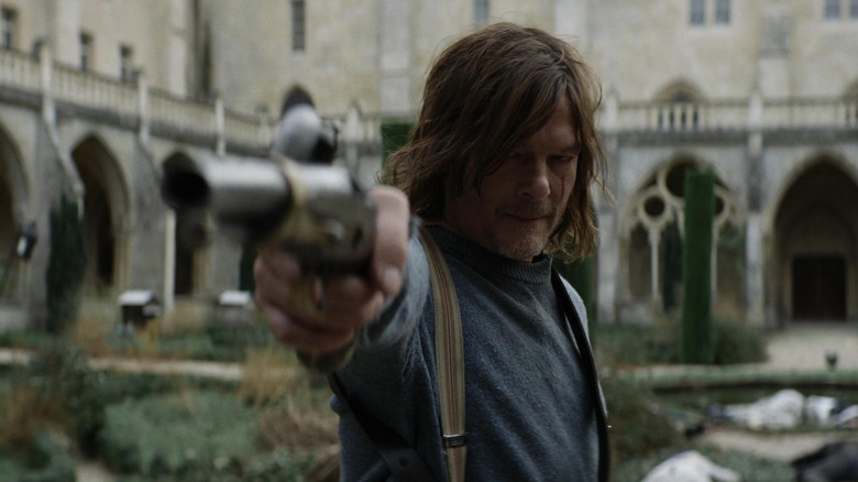 Norman Reedus as Daryl Dixon holding out a flintlock pistol in The Walking Dead: Daryl Dixon