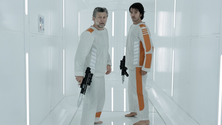 Kino Loy (Andy Serkis) and Cassian Andor (Diego Luna) holding blasters in Andor season 1