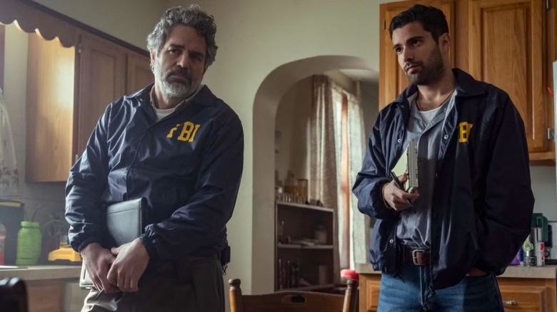 Mark Ruffalo as Tom Brandis and Fabien Frankel as Anthony Grasso in FBI jackets stood in a kitchen with notepads in Task