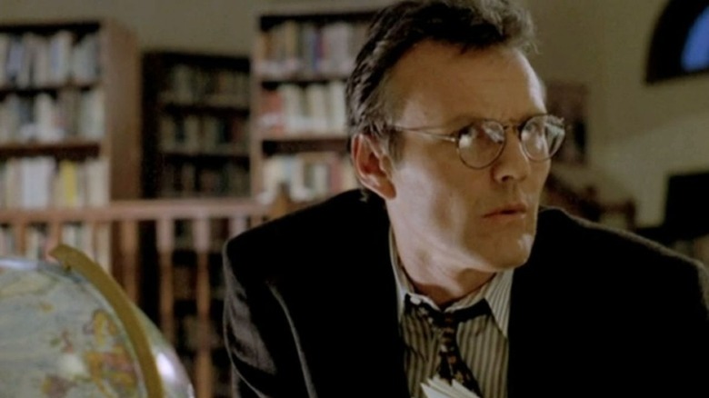Giles stands, wearing a tweed jacket, and looks at something to his right offscreen in "Buffy the Vampire Slayer"