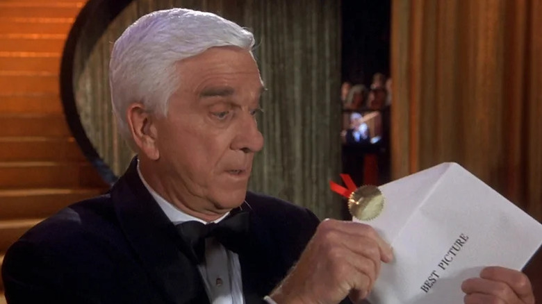 Frank Drebin looking in an Oscars envelope in The Naked Gun 33 ⅓: The Final Insult