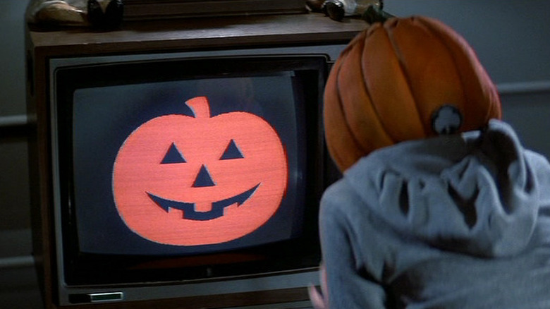Uma criança sentada em frente à TV durante um comercial do Silver Shamrock em Halloween III: Season of the Witch