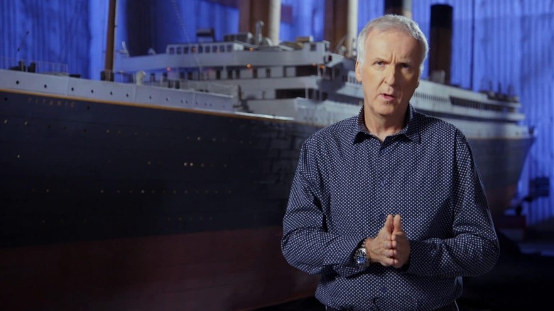 James Cameron narrating to the camera with the Titanic behind him in Titanic: 25 Years Later with James Cameron