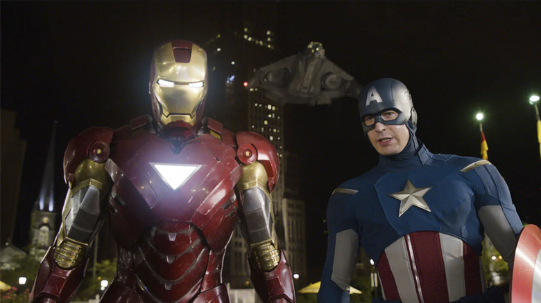 Iron Man and Captain America stand side by side with a ship flying behind them in The Avengers