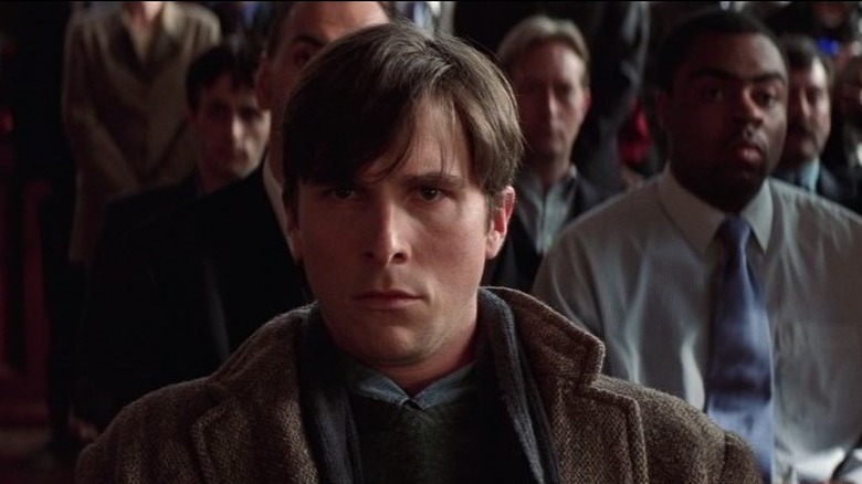 Christian Bale as Bruce Wayne sitting in court at Joe Chill's trial in Batman Begins