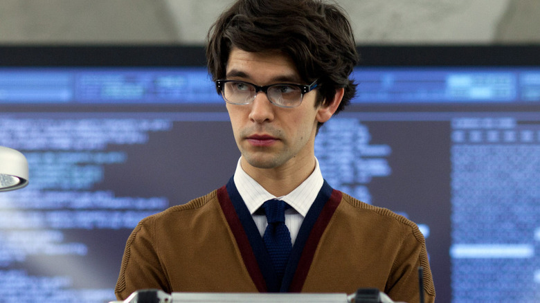 Q (Ben Whishaw) standing in front of a massive computer screen in 