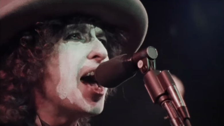 Bob Dylan sings into a microphone on the Rolling Thunder Revue tour in Rolling Thunder Revue: A Bob Dylan Story