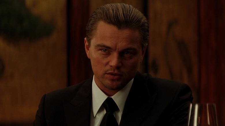 Leonardo DiCaprio as Dom Cobb sits in a suit in Inception