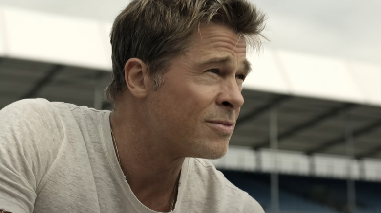 Brad Pitt as Sonny Hayes looks up at a grey sky in F1