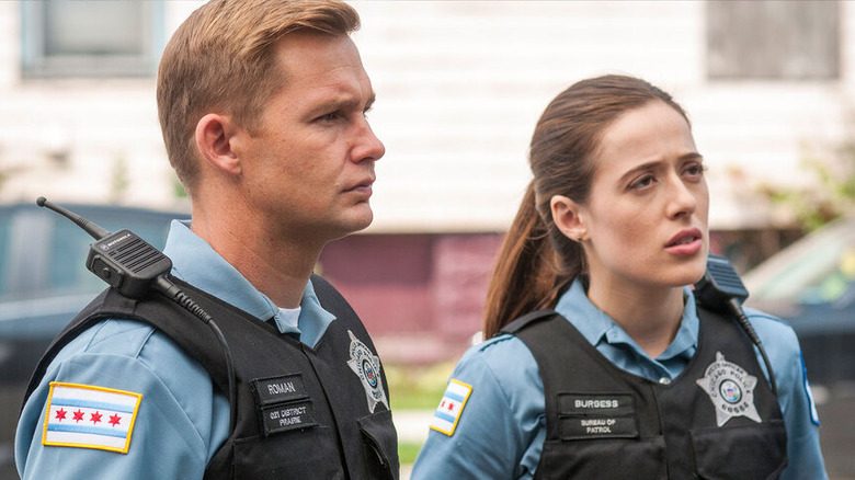Brian Geraghty's Sean Roman stands in uniform alongside Marina Squerciati's Kim Burgess in Chicago P.D.
