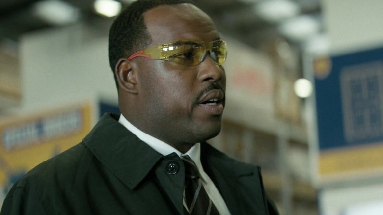 Lionel Boyce as Carl wearing his glasses at the checkout line in the hardware store in Project Hail Mary