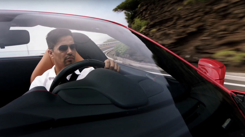 Jay Hernandez's Thomas Magnum is seen through the windshield driving his car in Magnum PI