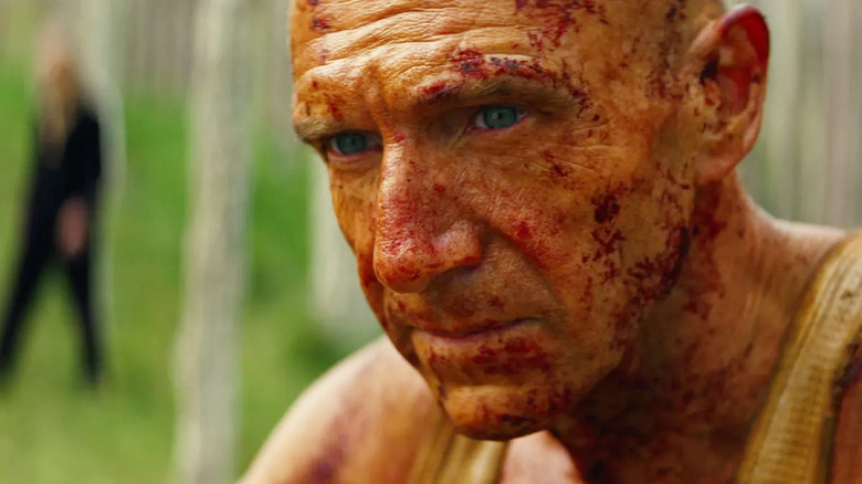 Ralph Fiennes as Kelson sitting and looking thoughtful in 28 Years Later: The Bone Temple