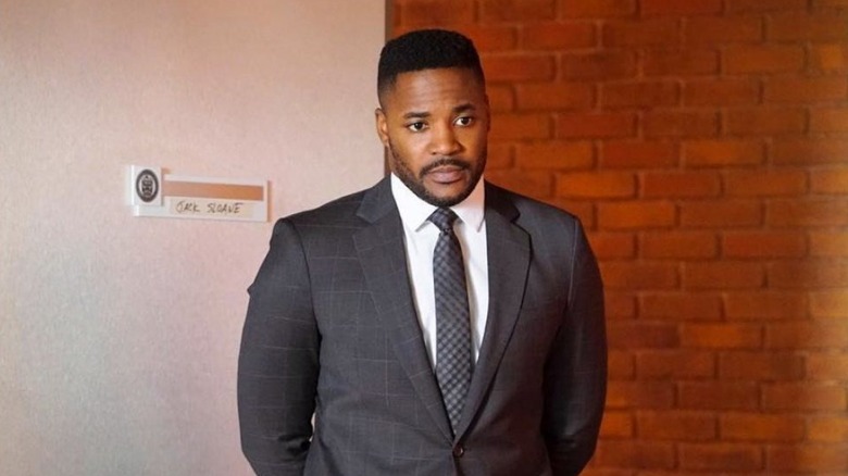 Clayton stands with his hands behind his back on NCIS