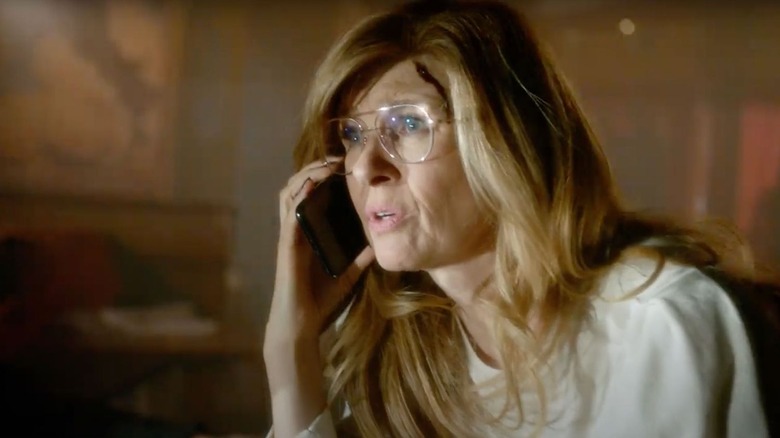Abby Clark (Connie Britton) holds a phone to her ear and looks worried.