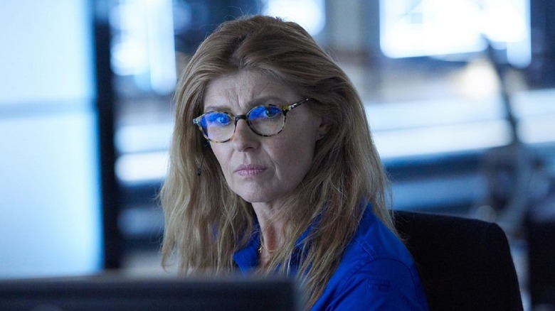 Abby Clark (Connie Britton) sits at a desk and looks pensively at a computer screen.
