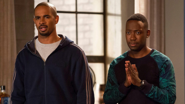 Coach and Winston looking confused at something in the loft on New Girl