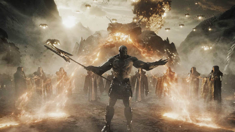 DDarkseid raises his arms surrounded by his soldiers in a scorched landscape in Zack Snyder's Justice League