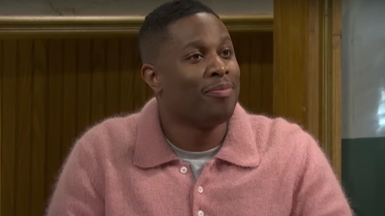 Devon Walker wearing a pink sweater and smiling on Saturday Night Live