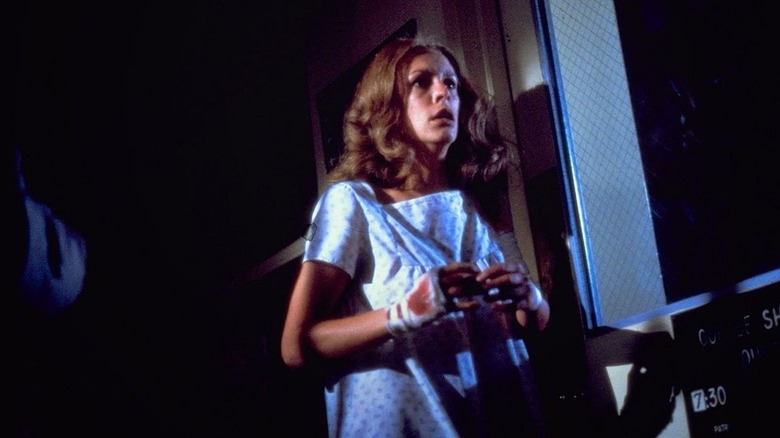 Jamie Lee Curtis' Laurie Strode running away in the hospital in her gown in Halloween II (1981)