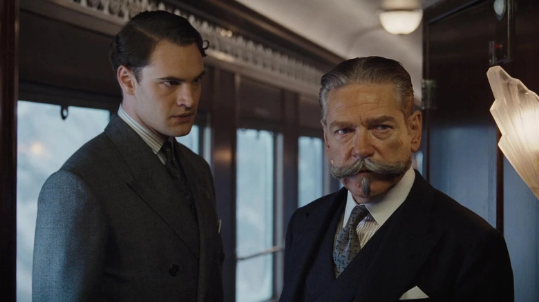 Bouc and Poirot on a train in Murder on the Orient Express