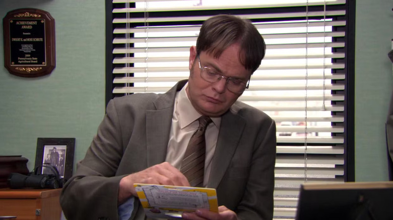 The Office: Dwight reviews something at his desk