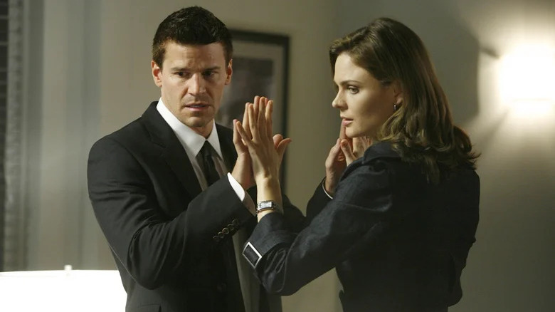 Emily Deschanel's Temperance Brennan holds her hands up against the hands of David Boreanaz's Agent Seeley Booth in Bones