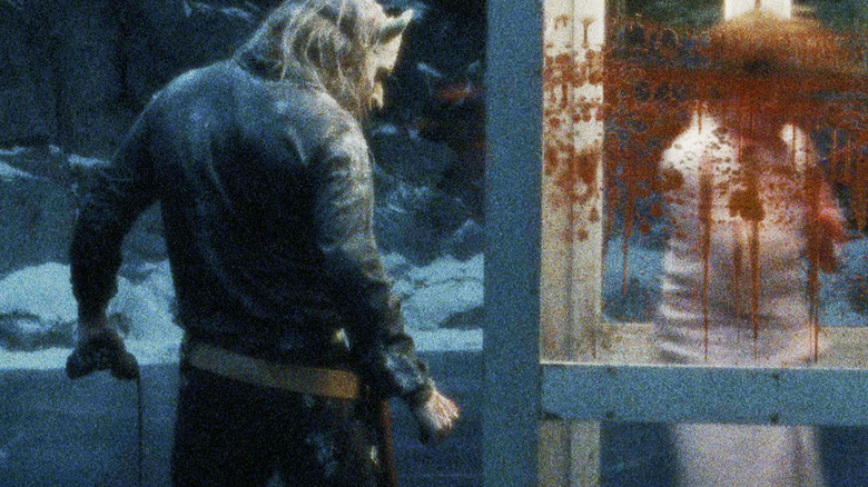 Ethan Hawke as The Grabber stands next to a phone booth splattered with blood in Black Phone 2