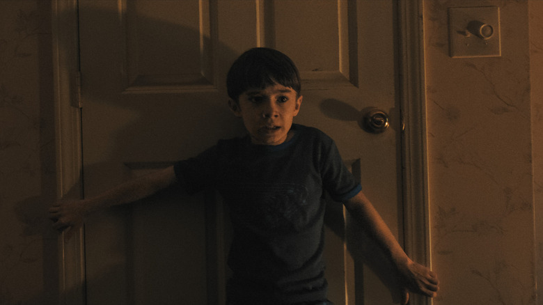 Alex holding a door shut in Weapons