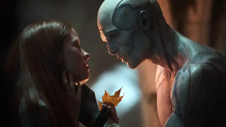 Elizabeth handing a leaf to the Monster in 2025's Frankenstein